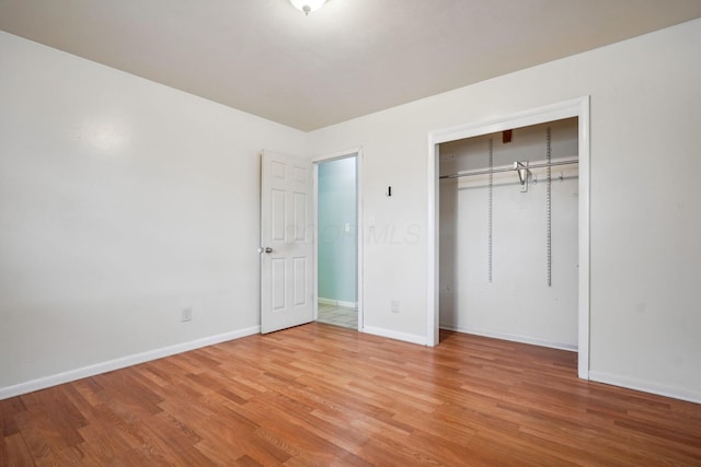 unfurnished bedroom with light hardwood / wood-style flooring and a closet