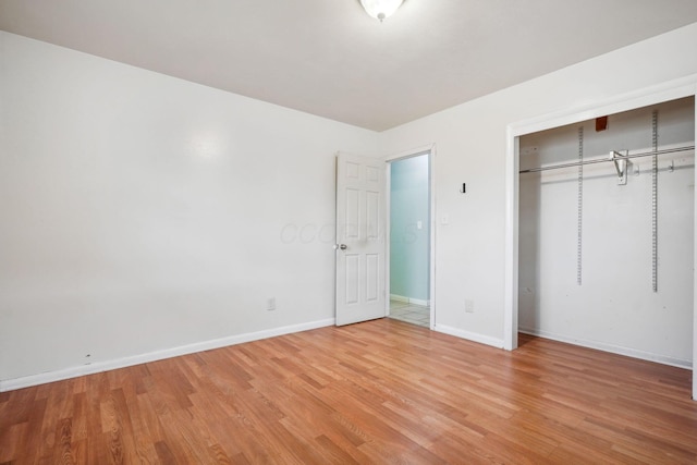 unfurnished bedroom with wood-type flooring and a closet