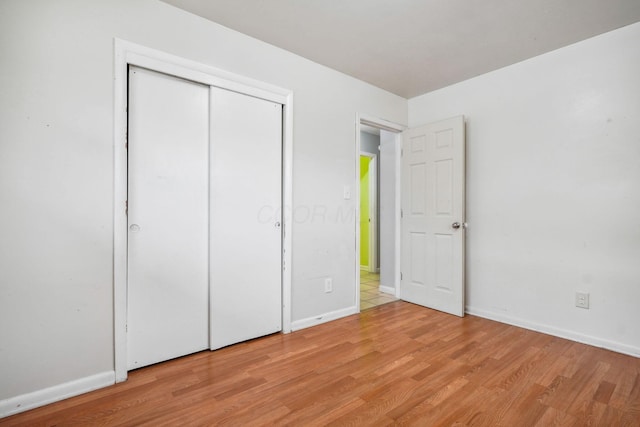 unfurnished bedroom featuring a closet and light wood-type flooring