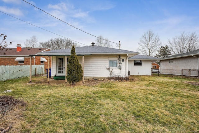 rear view of house featuring a lawn