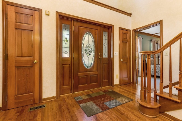 entrance foyer with wood-type flooring and crown molding