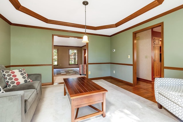 living room with a tray ceiling, light hardwood / wood-style flooring, and ornamental molding