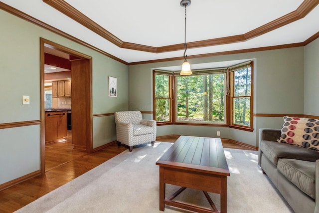 living room with a raised ceiling, ornamental molding, and hardwood / wood-style floors