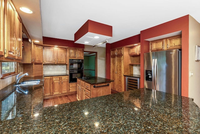 kitchen featuring sink, wine cooler, black appliances, decorative backsplash, and dark stone counters