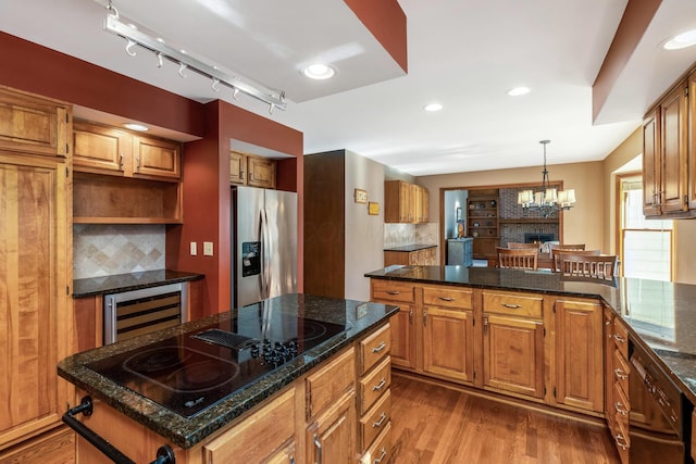 kitchen featuring wine cooler, stainless steel fridge, a center island, black electric stovetop, and light hardwood / wood-style floors