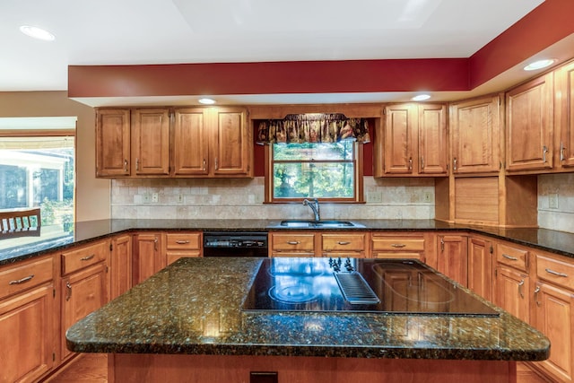 kitchen with dark stone countertops, sink, black appliances, and a center island