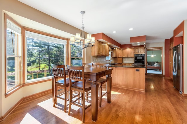 kitchen featuring stainless steel refrigerator, a wealth of natural light, light hardwood / wood-style flooring, and backsplash