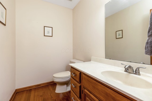 bathroom featuring wood-type flooring, toilet, and vanity