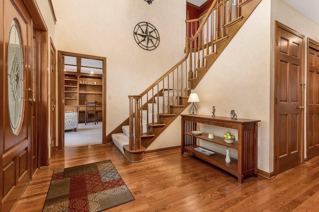 foyer entrance with wood-type flooring and a high ceiling