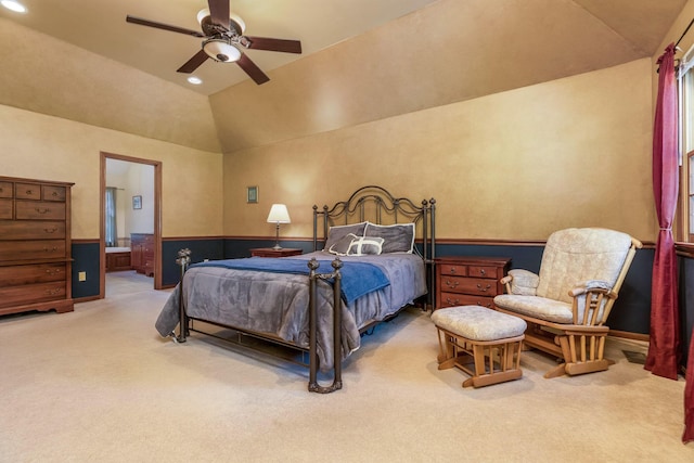 carpeted bedroom featuring vaulted ceiling, ceiling fan, and ensuite bath