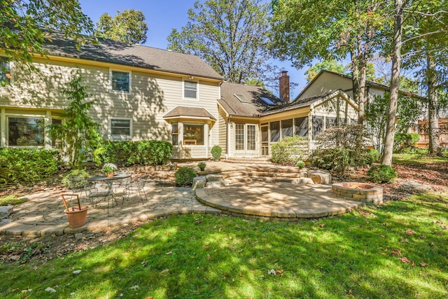 back of house featuring a sunroom, a lawn, and a patio area