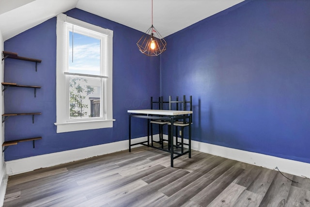 dining area with hardwood / wood-style flooring and vaulted ceiling