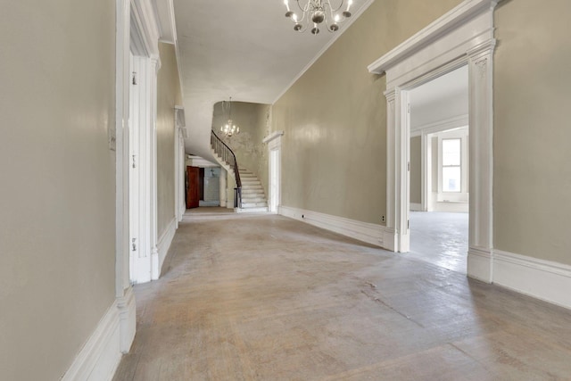 corridor with crown molding and a chandelier