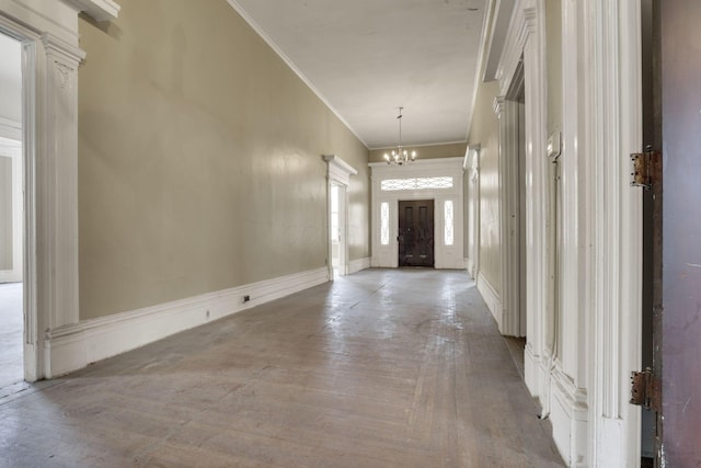 corridor featuring crown molding and a notable chandelier