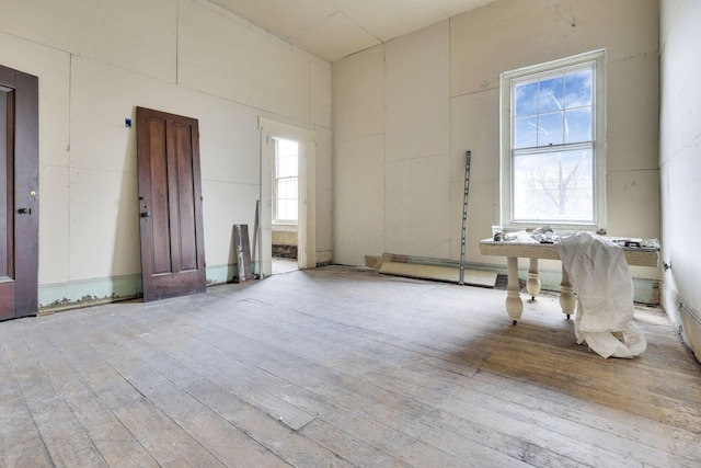 empty room with a high ceiling and light wood-type flooring