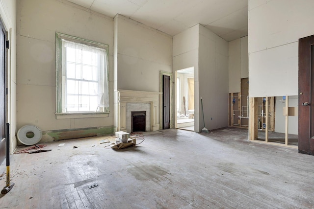 unfurnished living room with a brick fireplace and a towering ceiling