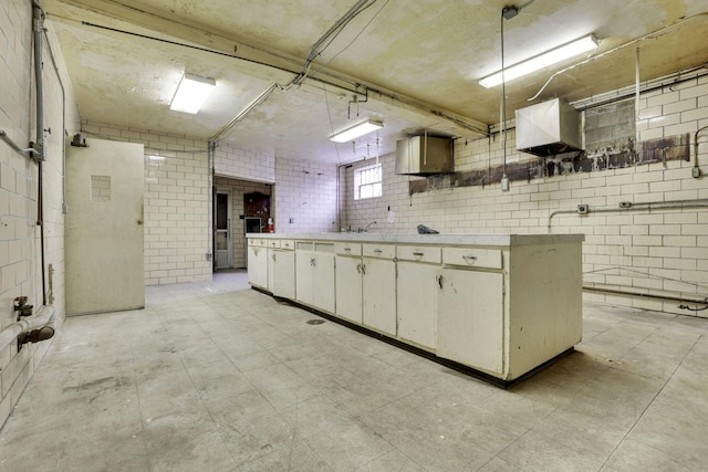 kitchen with hanging light fixtures and brick wall