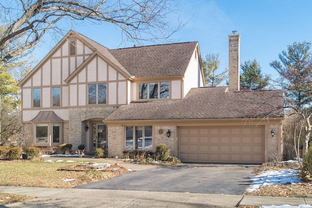 english style home featuring a garage