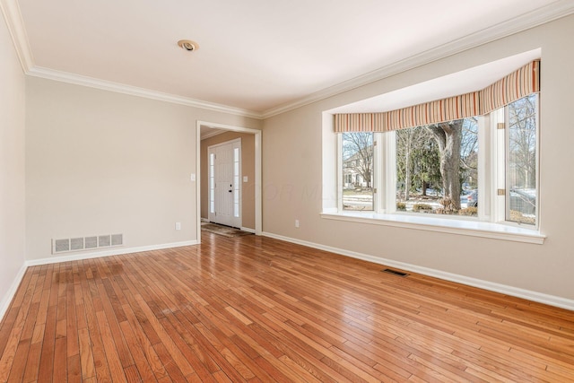 spare room with crown molding and light wood-type flooring