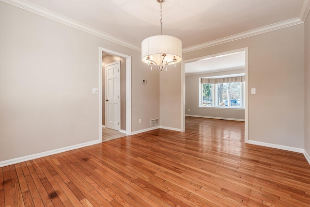 unfurnished room with an inviting chandelier, ornamental molding, and light hardwood / wood-style floors