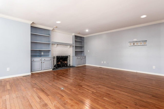 unfurnished living room featuring a fireplace, built in features, wood-type flooring, and ornamental molding