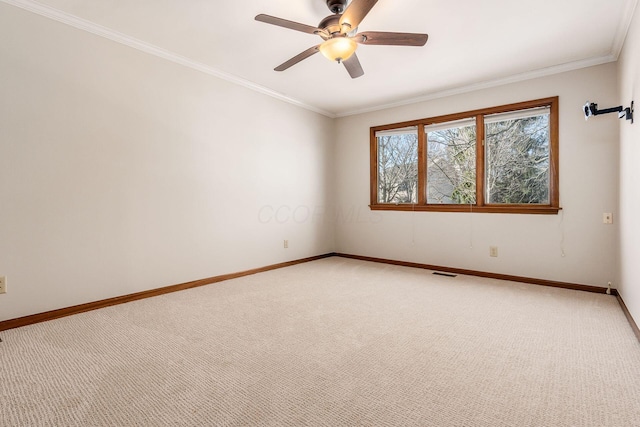 spare room featuring ornamental molding, ceiling fan, and carpet