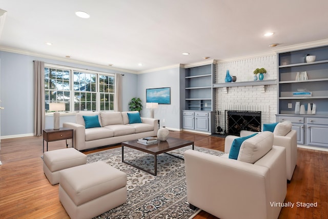 living room with crown molding, a fireplace, and light hardwood / wood-style flooring