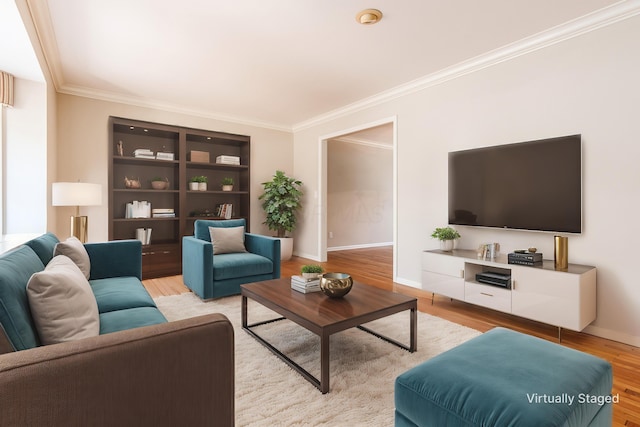 living room with crown molding, built in shelves, and light hardwood / wood-style flooring