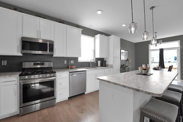 kitchen with white cabinetry, decorative backsplash, a center island, and appliances with stainless steel finishes