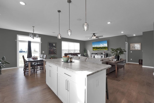 kitchen featuring dark hardwood / wood-style flooring, hanging light fixtures, a center island, and white cabinets