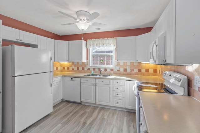 kitchen featuring tasteful backsplash, sink, white cabinets, light hardwood / wood-style floors, and white appliances