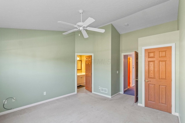 unfurnished bedroom with ceiling fan, lofted ceiling, light carpet, and ensuite bath