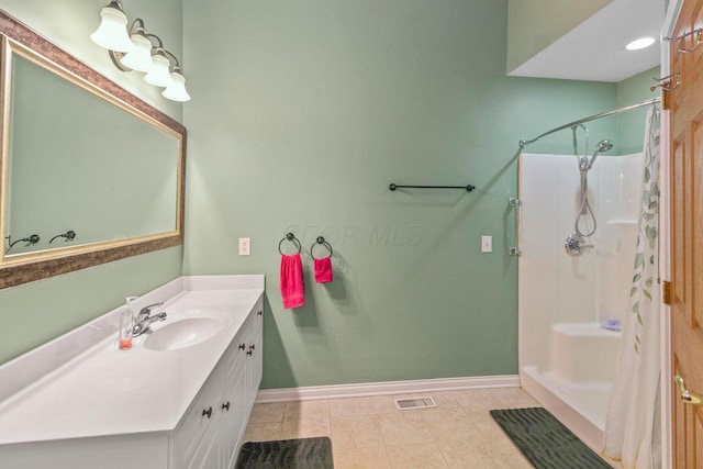 bathroom featuring vanity, tile patterned floors, and walk in shower