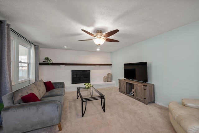 living room featuring brick wall, light colored carpet, a fireplace, and a textured ceiling