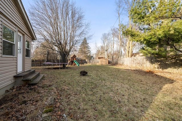 view of yard featuring a playground and a trampoline