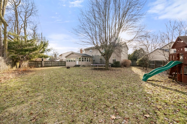 view of yard with a playground and a trampoline