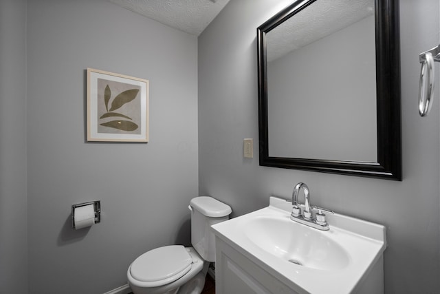 bathroom featuring vanity, toilet, and a textured ceiling