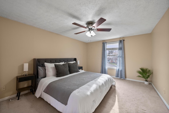 carpeted bedroom featuring a textured ceiling and ceiling fan