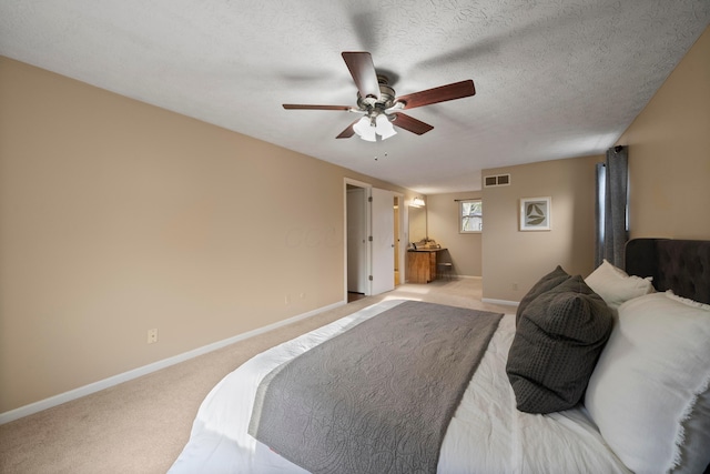 carpeted bedroom with ceiling fan and a textured ceiling