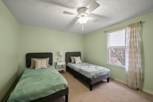 carpeted bedroom with a textured ceiling and ceiling fan