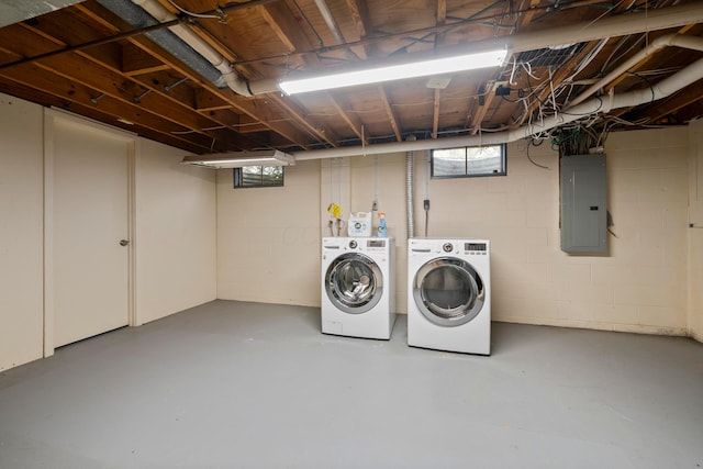 clothes washing area with electric panel and washer and dryer