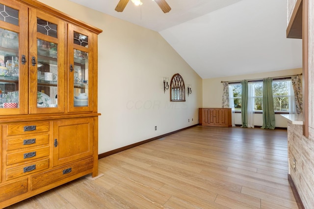 unfurnished living room featuring vaulted ceiling, light hardwood / wood-style floors, and ceiling fan