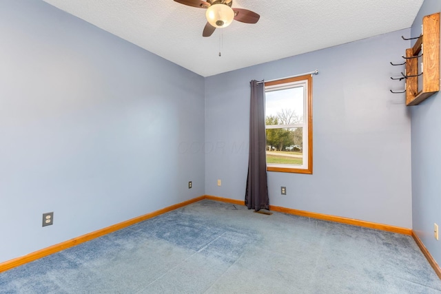 carpeted spare room featuring ceiling fan and a textured ceiling