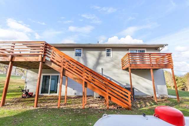 rear view of property with a deck and a lawn