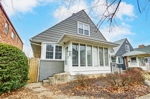 rear view of property featuring a sunroom