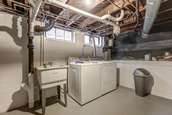 washroom with sink, electric panel, and washer and dryer