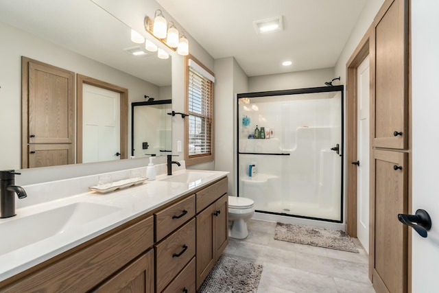 bathroom with tile patterned floors, toilet, a shower with door, and vanity