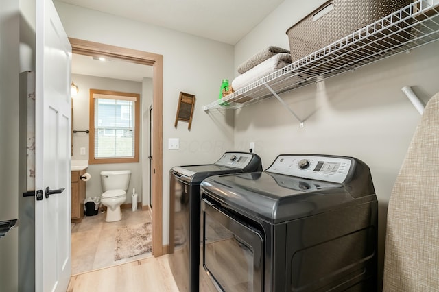 washroom with separate washer and dryer and light hardwood / wood-style floors