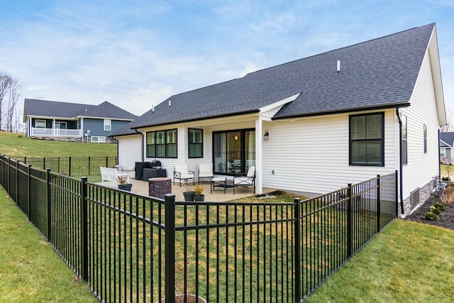 back of house with a fire pit, a yard, and a patio area