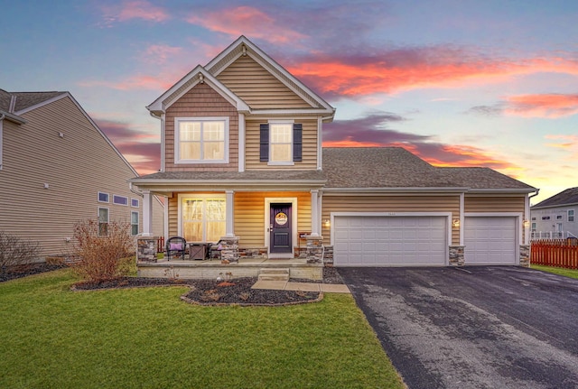 view of front of house featuring a porch, a garage, and a lawn